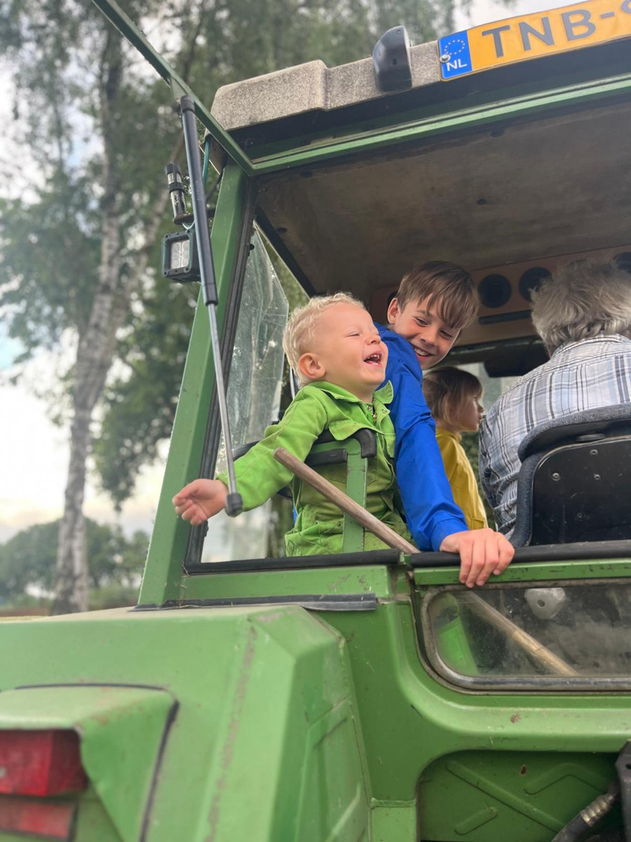 Zwei lachende Kinder in der Traktorkabine
